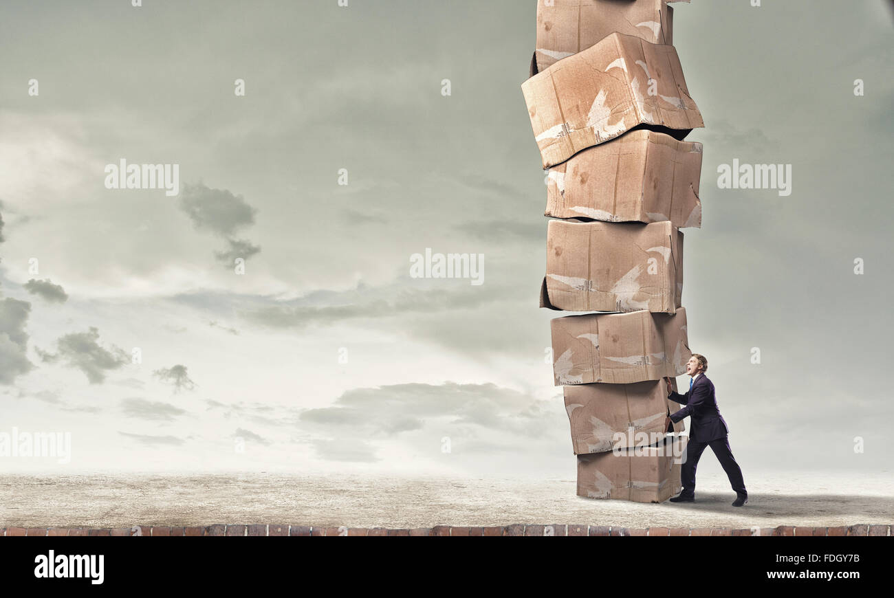 Move Stacking Young businessman making effort to move stack of carton boxes Stock ...