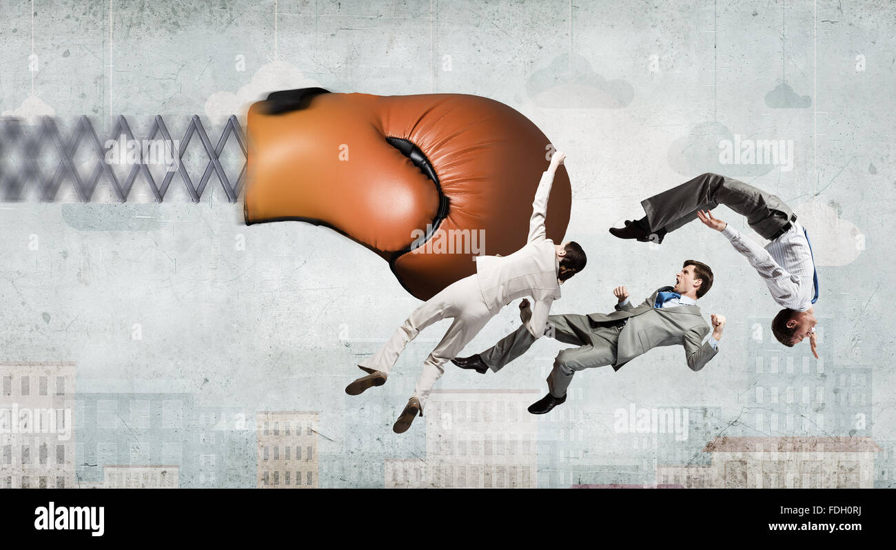 Boxing glove on spring striking group of businesspeople Stock Photo Alamy