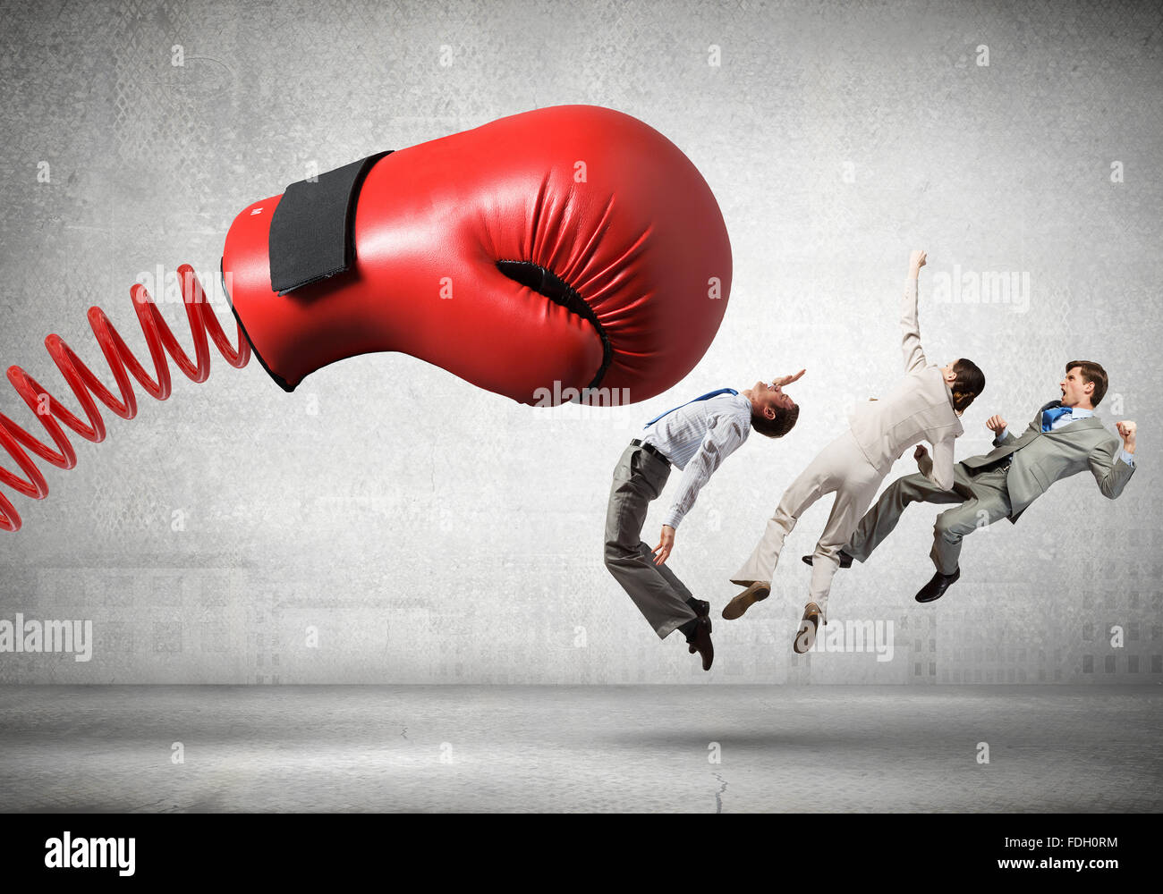 Boxing glove on spring striking group of businesspeople Stock Photo Alamy