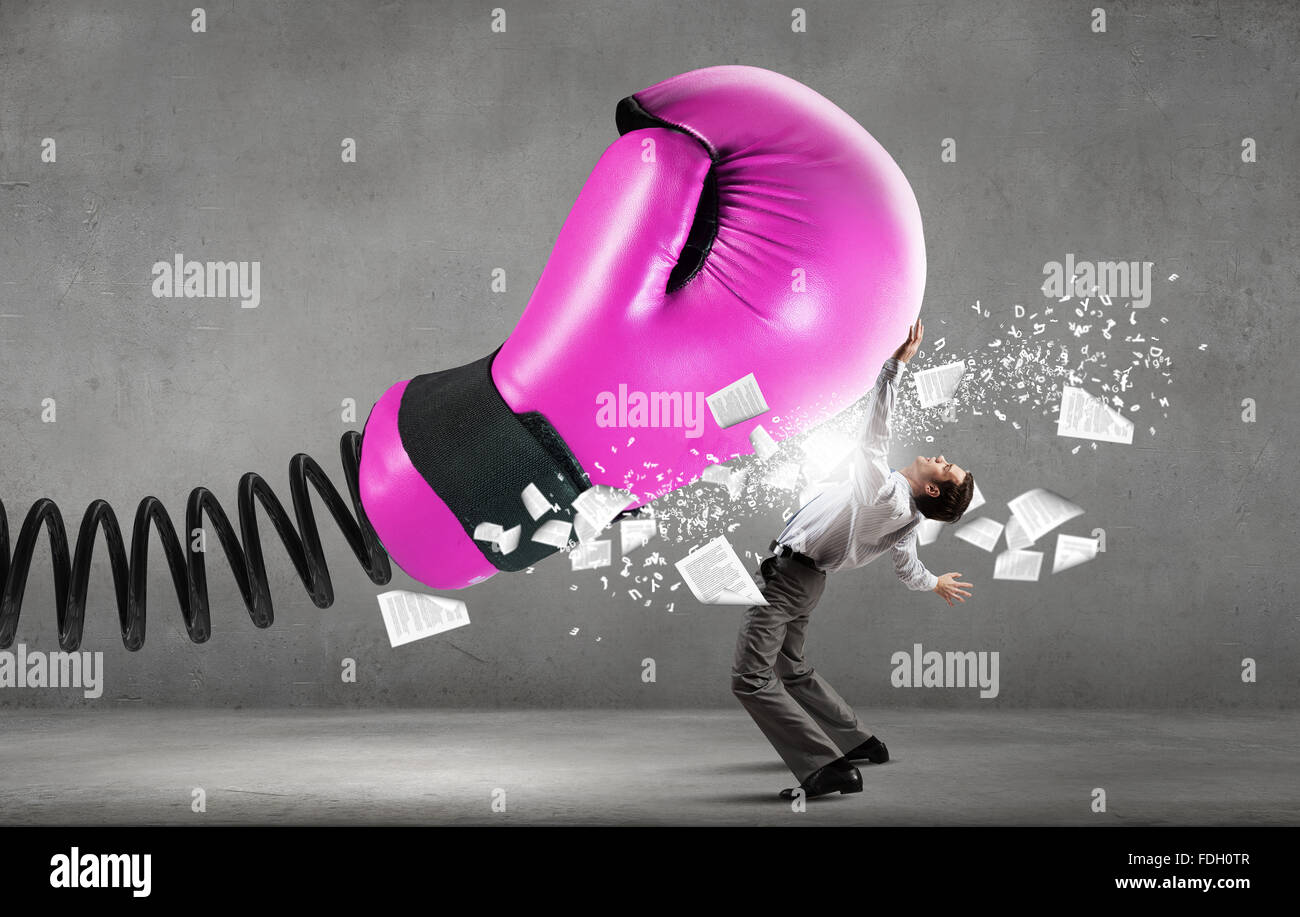 Young determined businessman fighting boxing glove on spring Stock