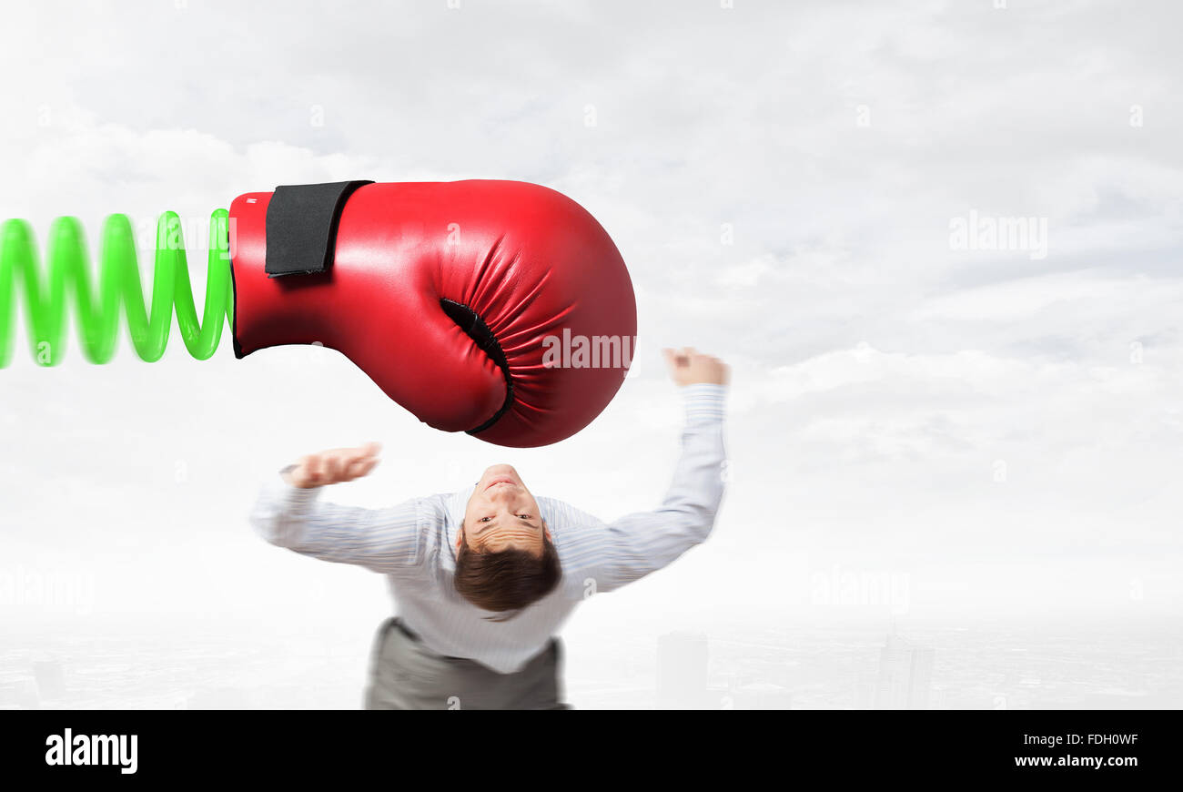 Young determined businessman fighting boxing glove on spring Stock