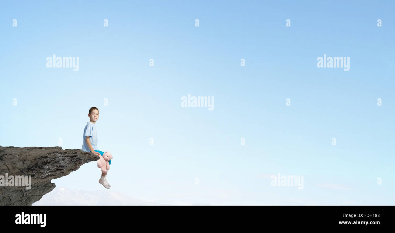 Cute little boy with toy bear on rock top Stock Photo - Alamy