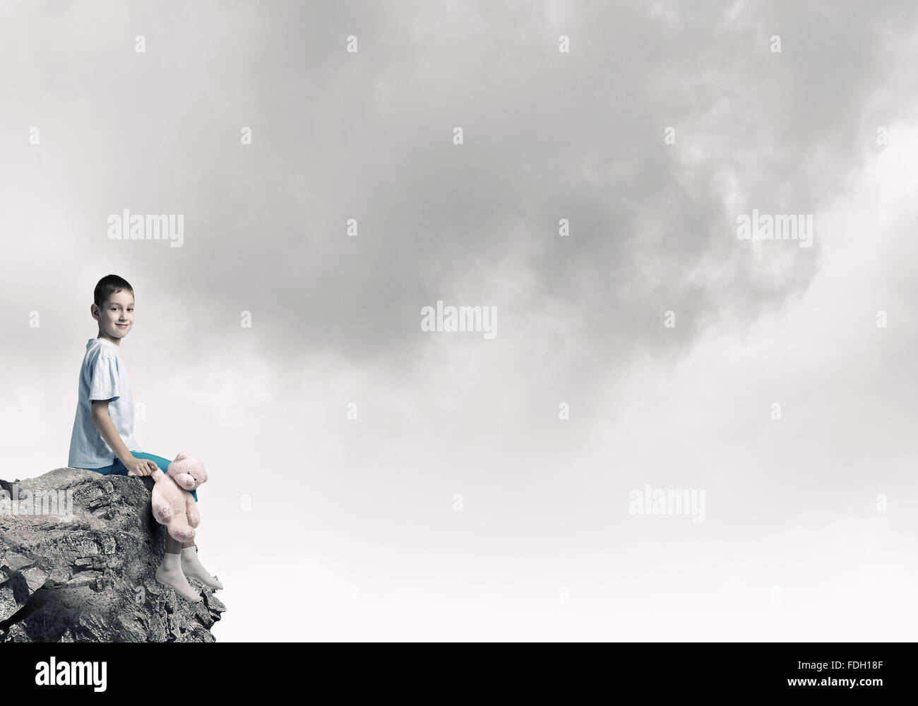 Cute little boy with toy bear on rock top Stock Photo - Alamy