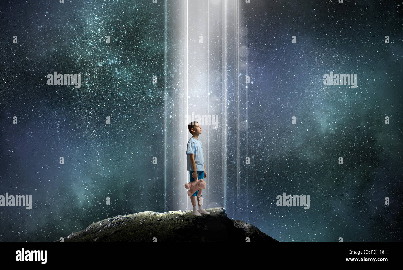 Cute little boy with toy bear on rock top Stock Photo - Alamy