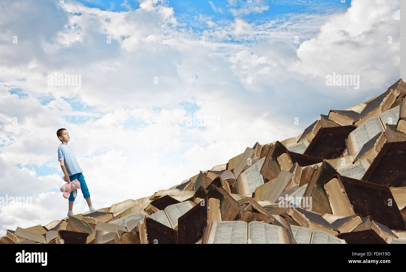 Cute little boy with toy bear on pile of books Stock Photo - Alamy