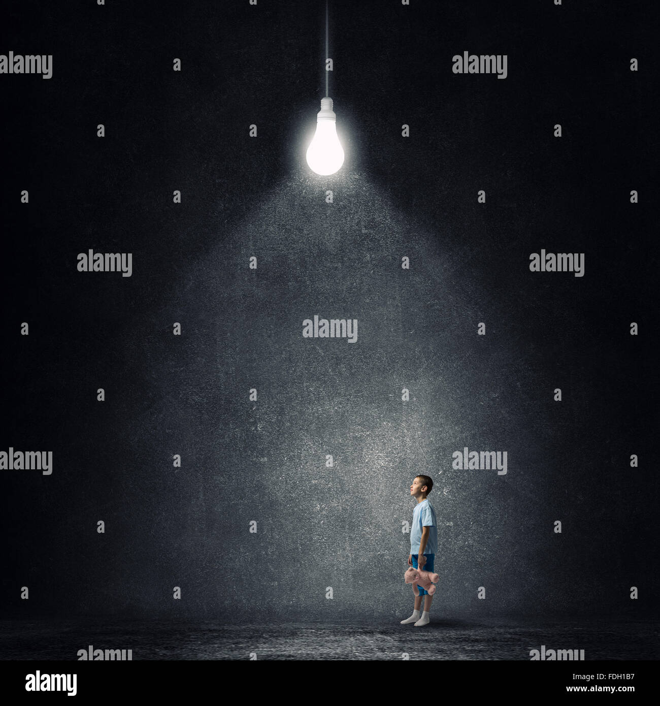 Cute little boy with toy bear in concrete dark room Stock Photo - Alamy
