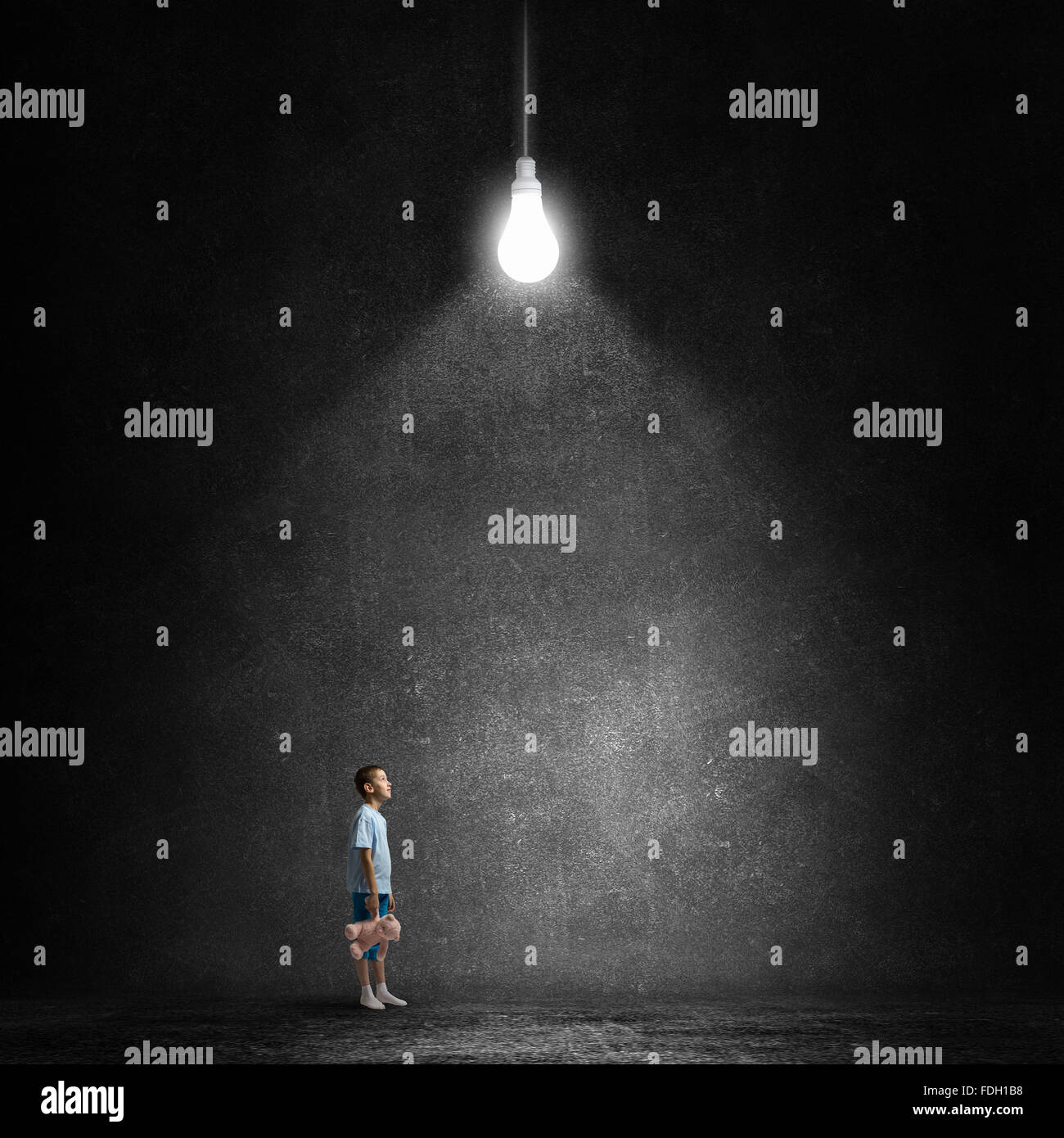 Cute little boy with toy bear in concrete dark room Stock Photo - Alamy
