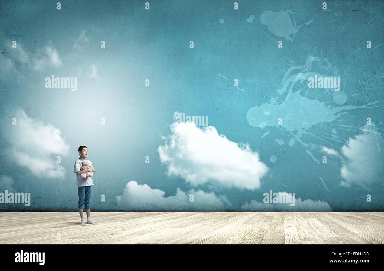 Cute little boy with toy bear on cloud background Stock Photo - Alamy