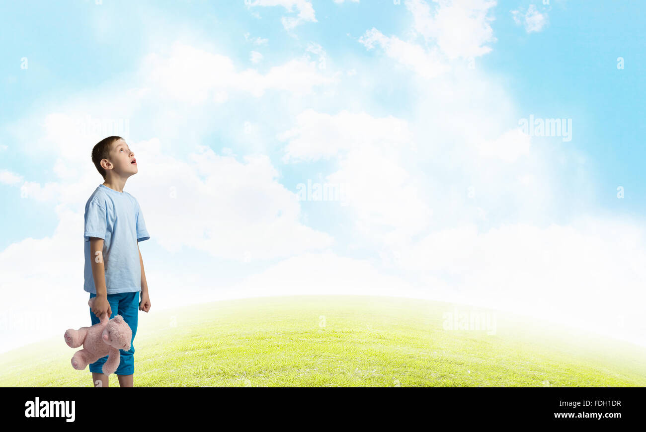 Cute little boy with toy bear on cloud background Stock Photo - Alamy