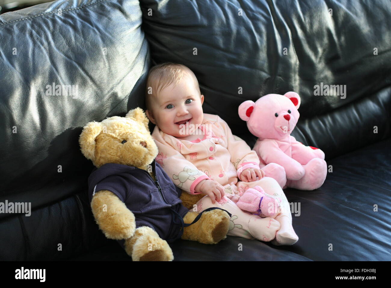 Baby girl child, kid laughing out loud with her teddy, family time, family happy joyful innocent childhood concept Stock Photo