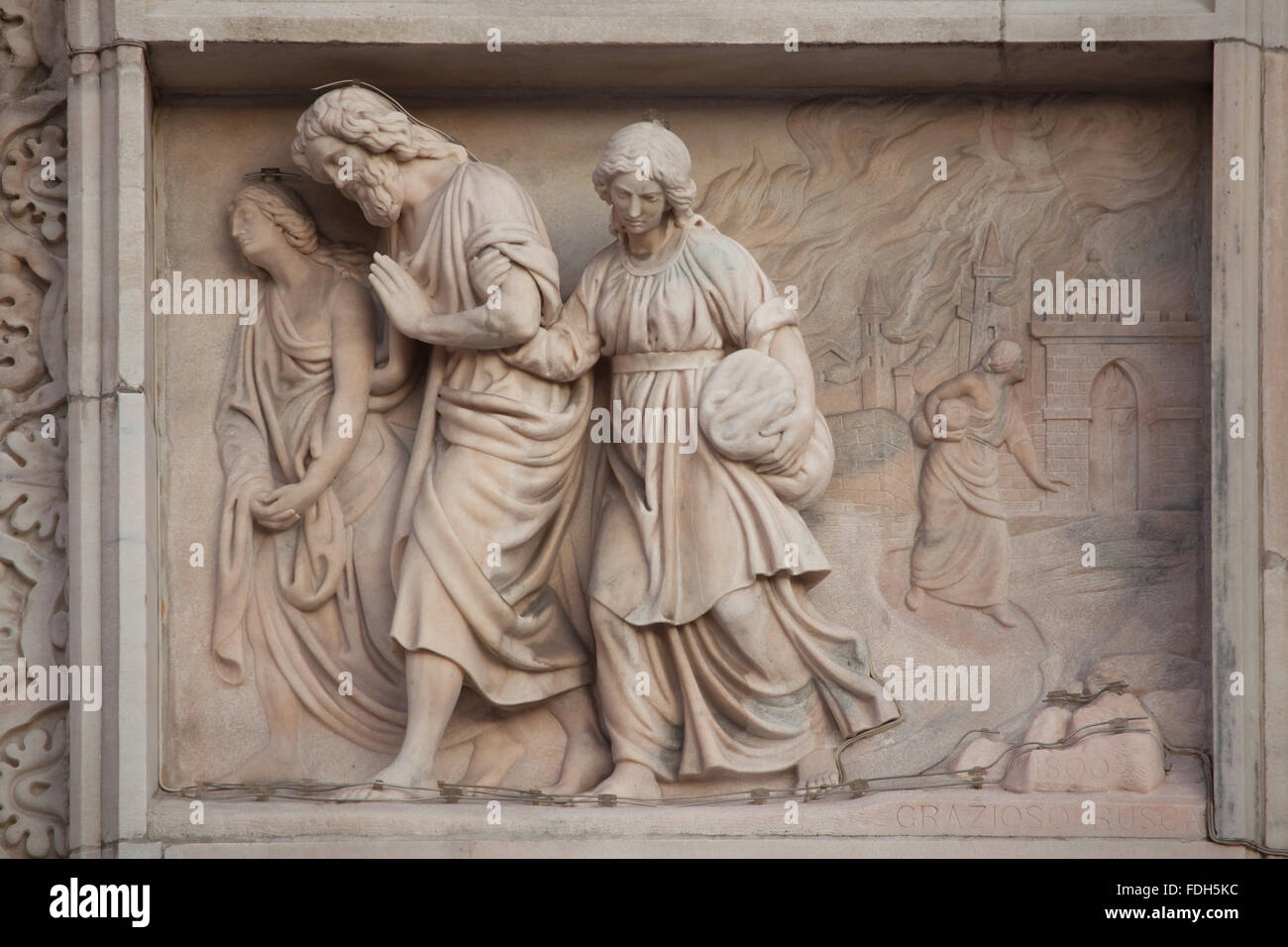 Lot and his daughters flee from Sodom. Marble relief (1800) by Italian sculptor Grazioso Rusca on the main facade of the Milan C Stock Photo