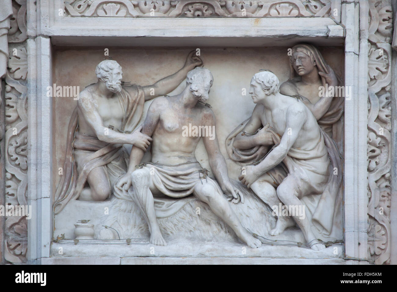 Job and his friends. Marble relief (1796) by Italian sculptor Carlo Maria Giudici on the main facade of the Milan Cathedral (Duo Stock Photo