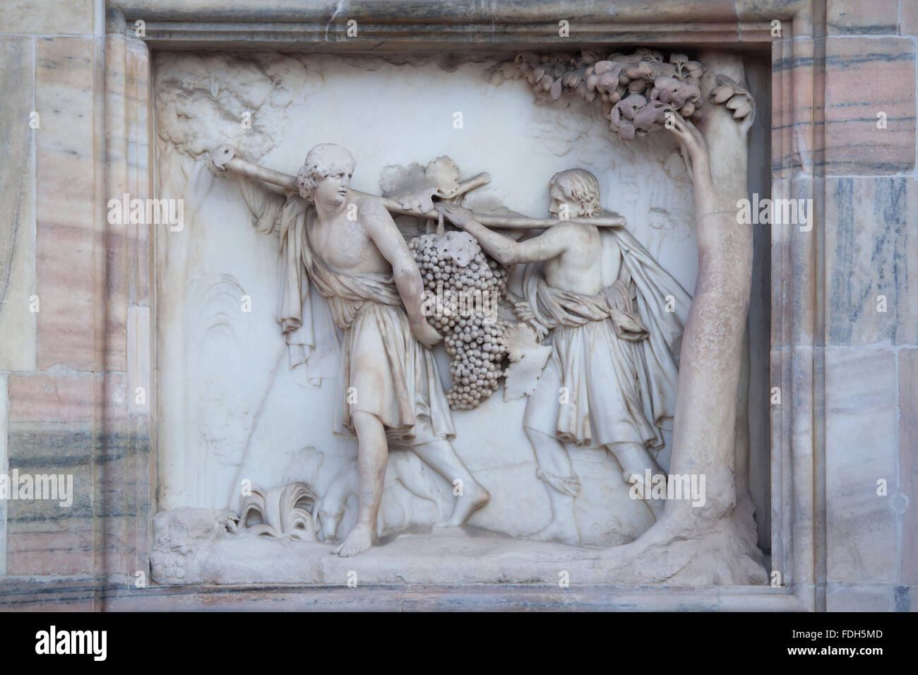 Israelites carrying the Grapes of Canaan. Marble relief by Italian sculptor Francesco Carabelli on the main facade of the Milan Stock Photo