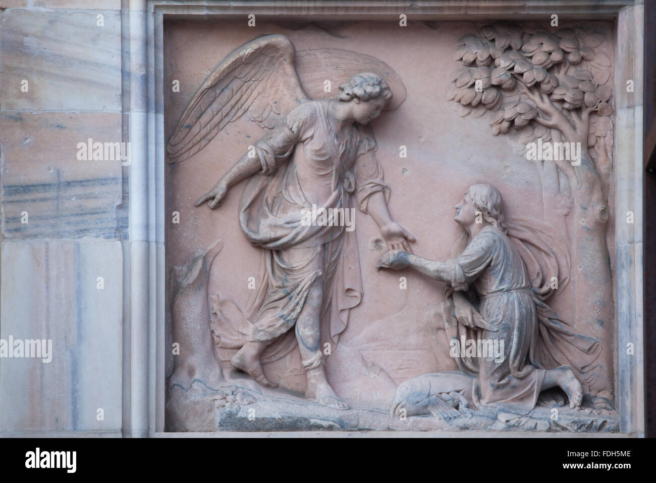 Angel Raphael and Tobias. Marble relief on the south facade of the Milan Cathedral (Duomo di Milano) in Milan, Lombardy, Italy. Stock Photo