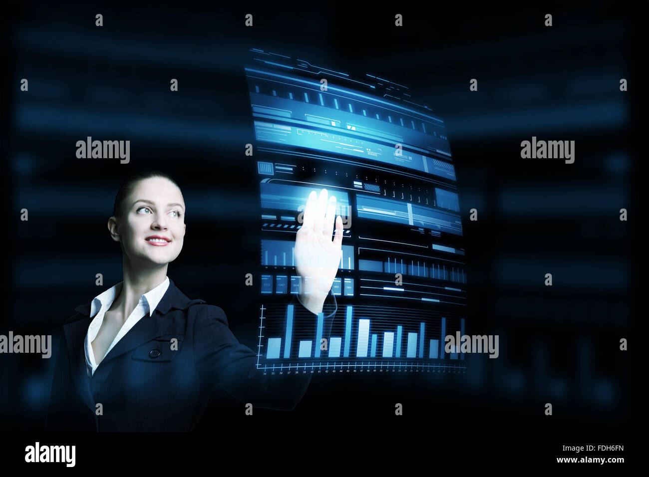 Attractive smiling businesswoman working with virtual panel interface ...