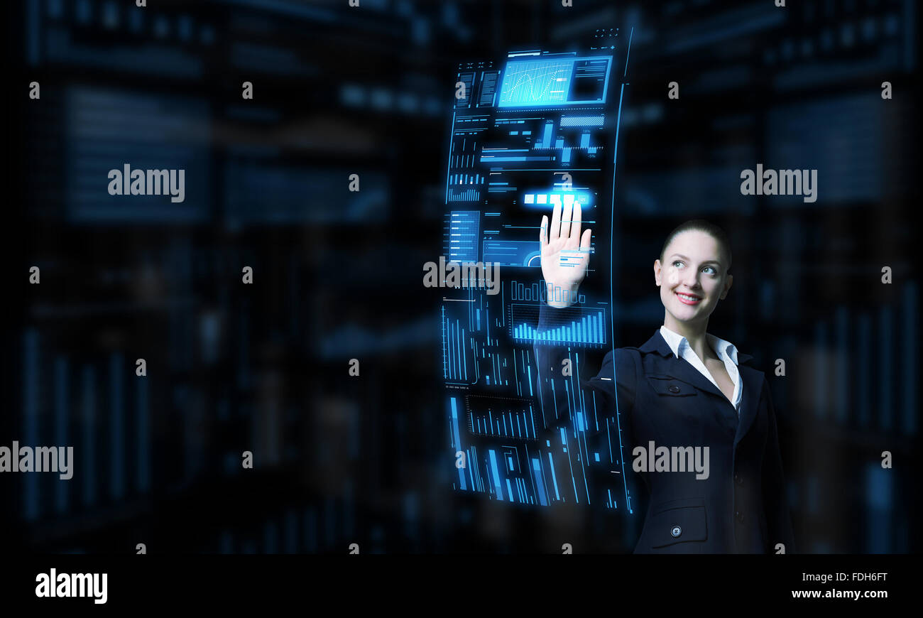 Attractive smiling businesswoman working with virtual panel interface ...
