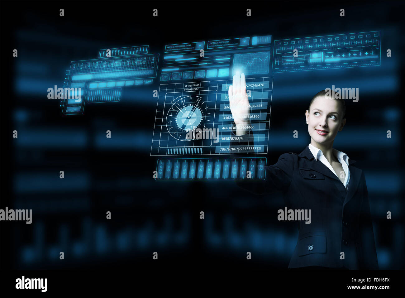 Attractive smiling businesswoman working with virtual panel interface ...