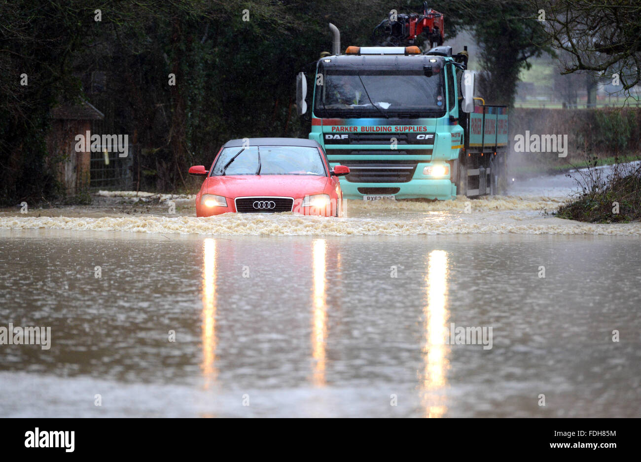 Car and lorry driving through flooded road. UK Stock Photo
