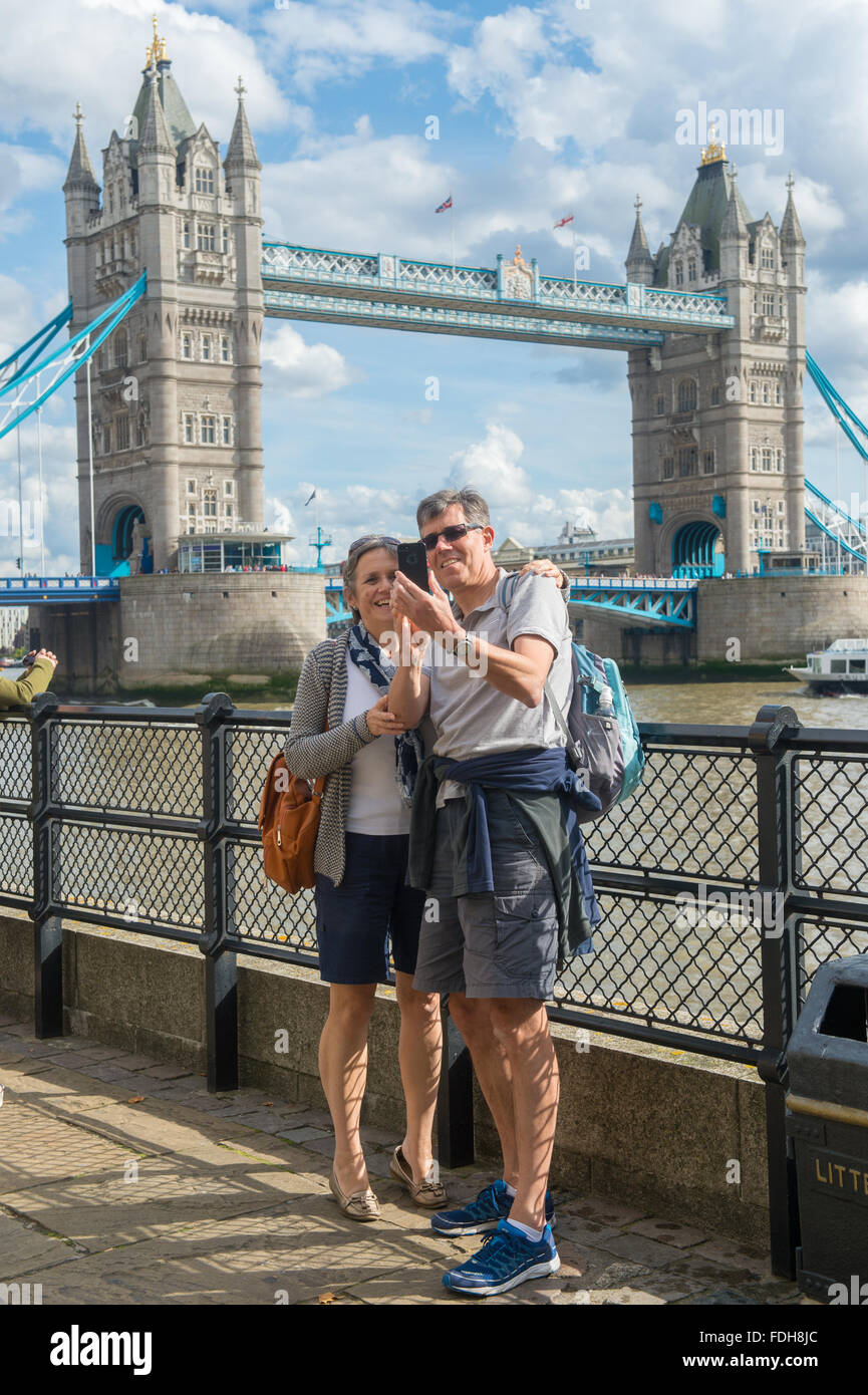Tourists taking a selfie in front of the Tower Bridge on the River Thames in London, England. Stock Photo