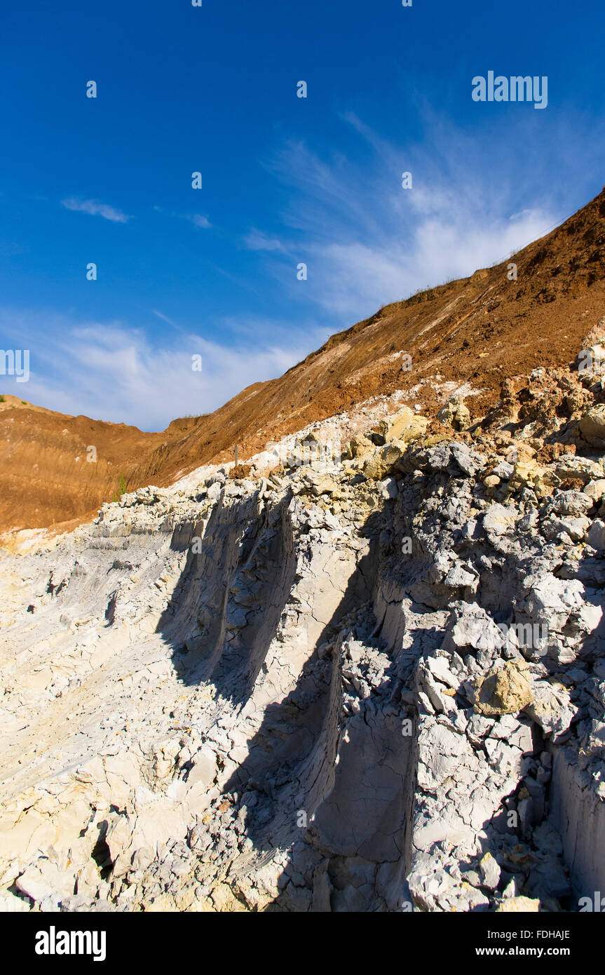 clay quarry with traces of the excavator bucket on blue sky background Stock Photo