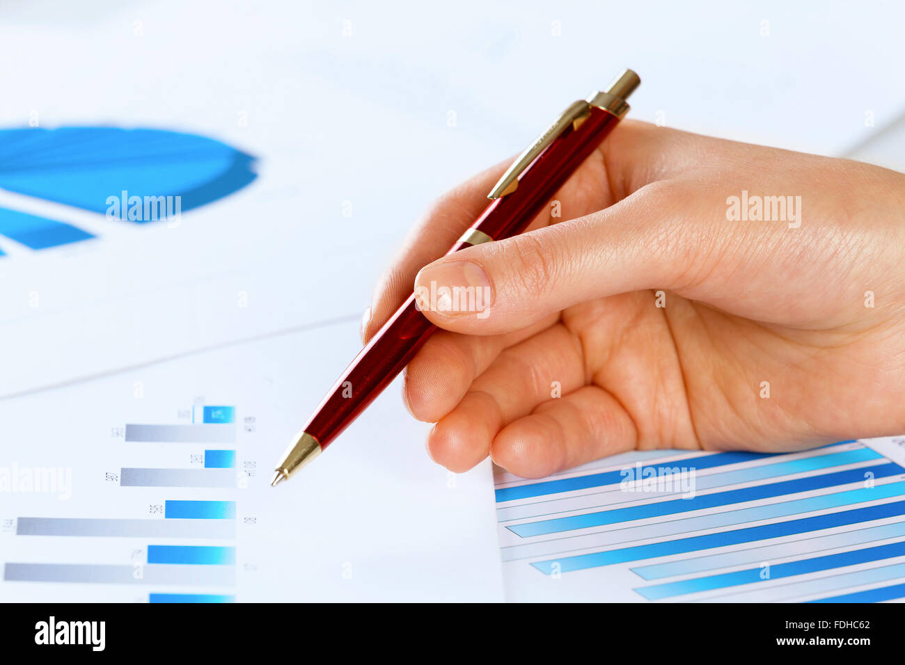 Close up of male hand holding pen pointing at graphs hi-res stock ...
