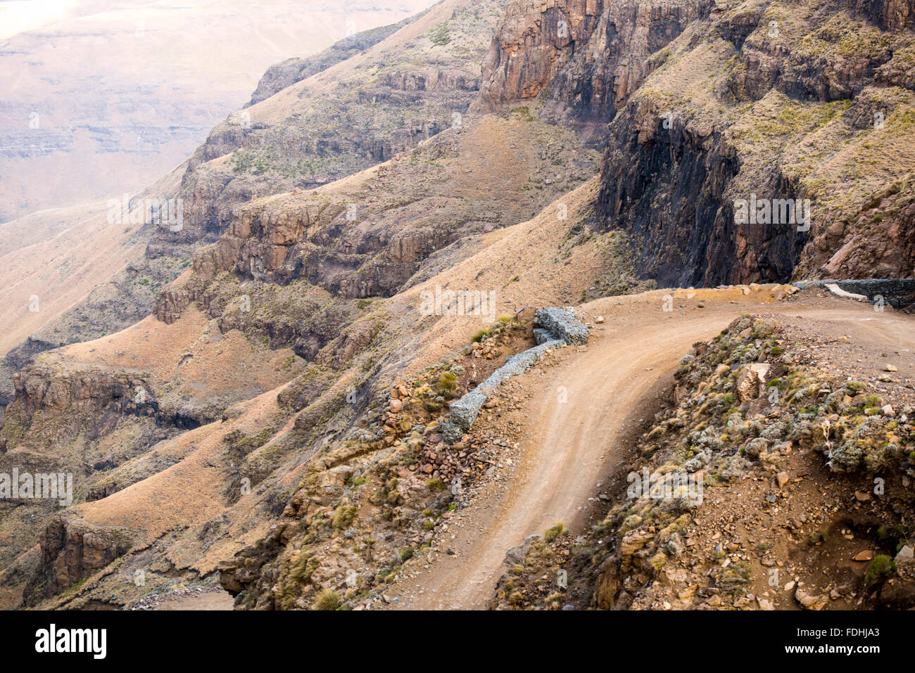 Empty dirt road winding through Sani Pass, between South Africa and Lesotho. Stock Photo