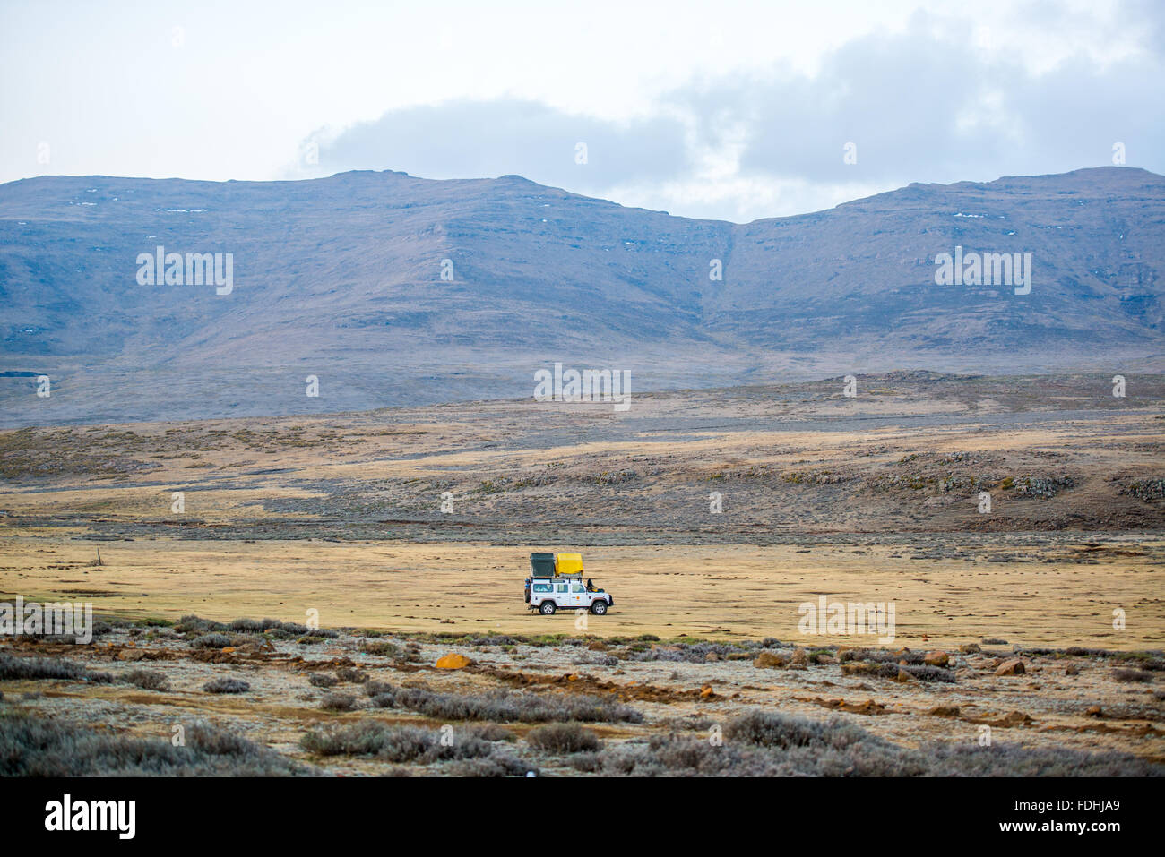 Land Rover Defender parked with tents set up for camping in Sani Pass, Lesotho, Africa. Stock Photo