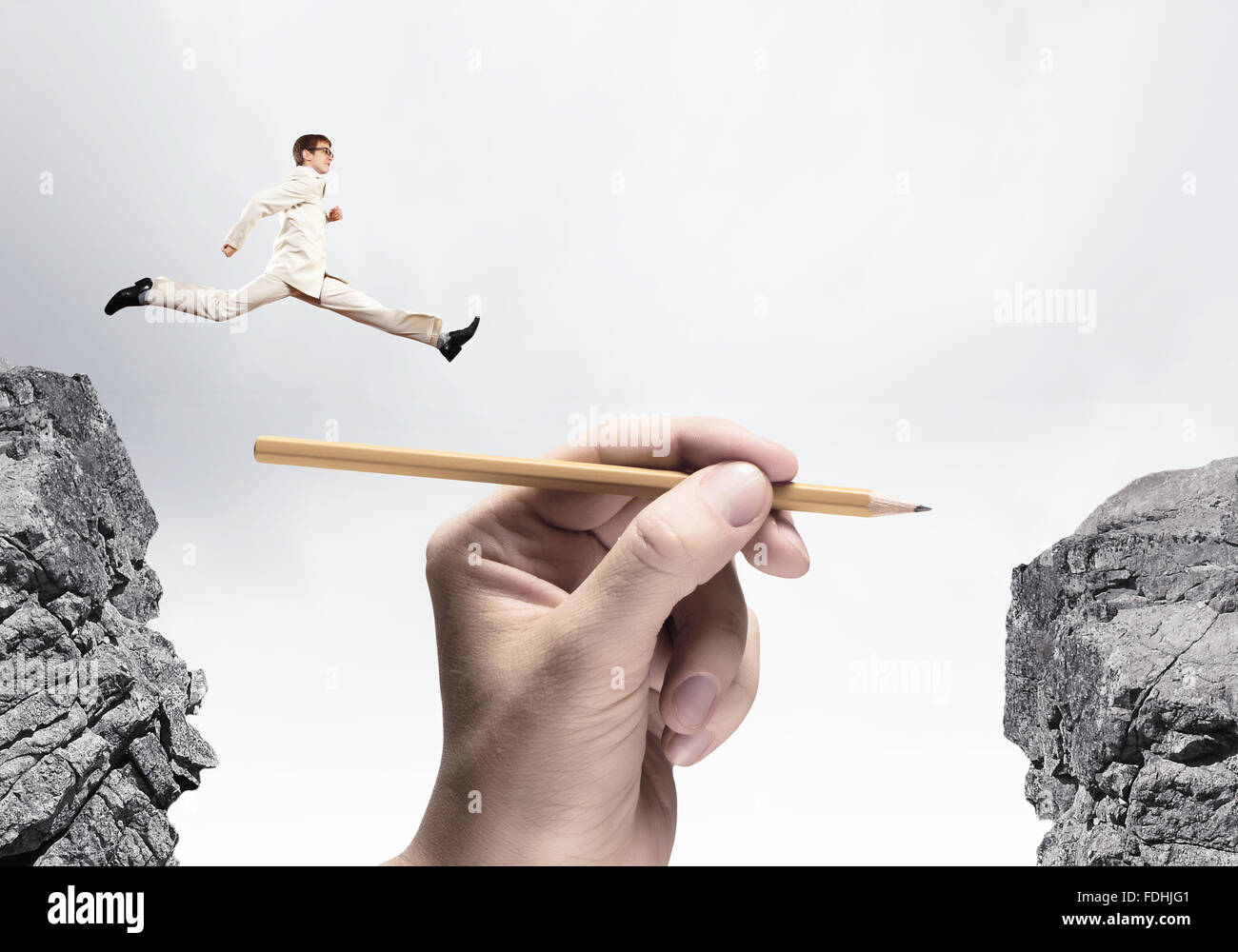 Young successful businessman jumping over gap. Risk and challenge ...