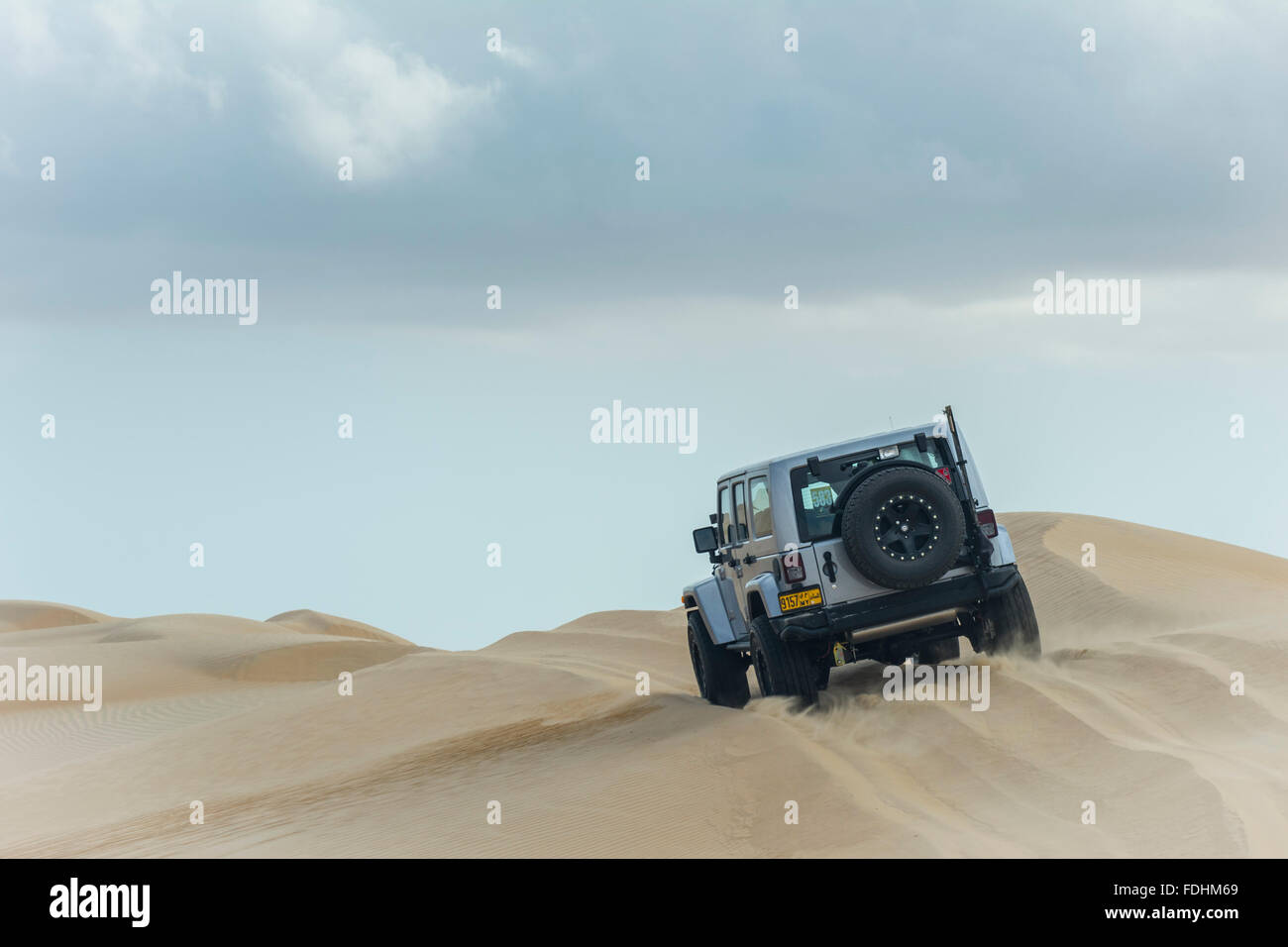 Jeep Wrangler Rubicon bashing dunes in Wahiba Sands Stock Photo