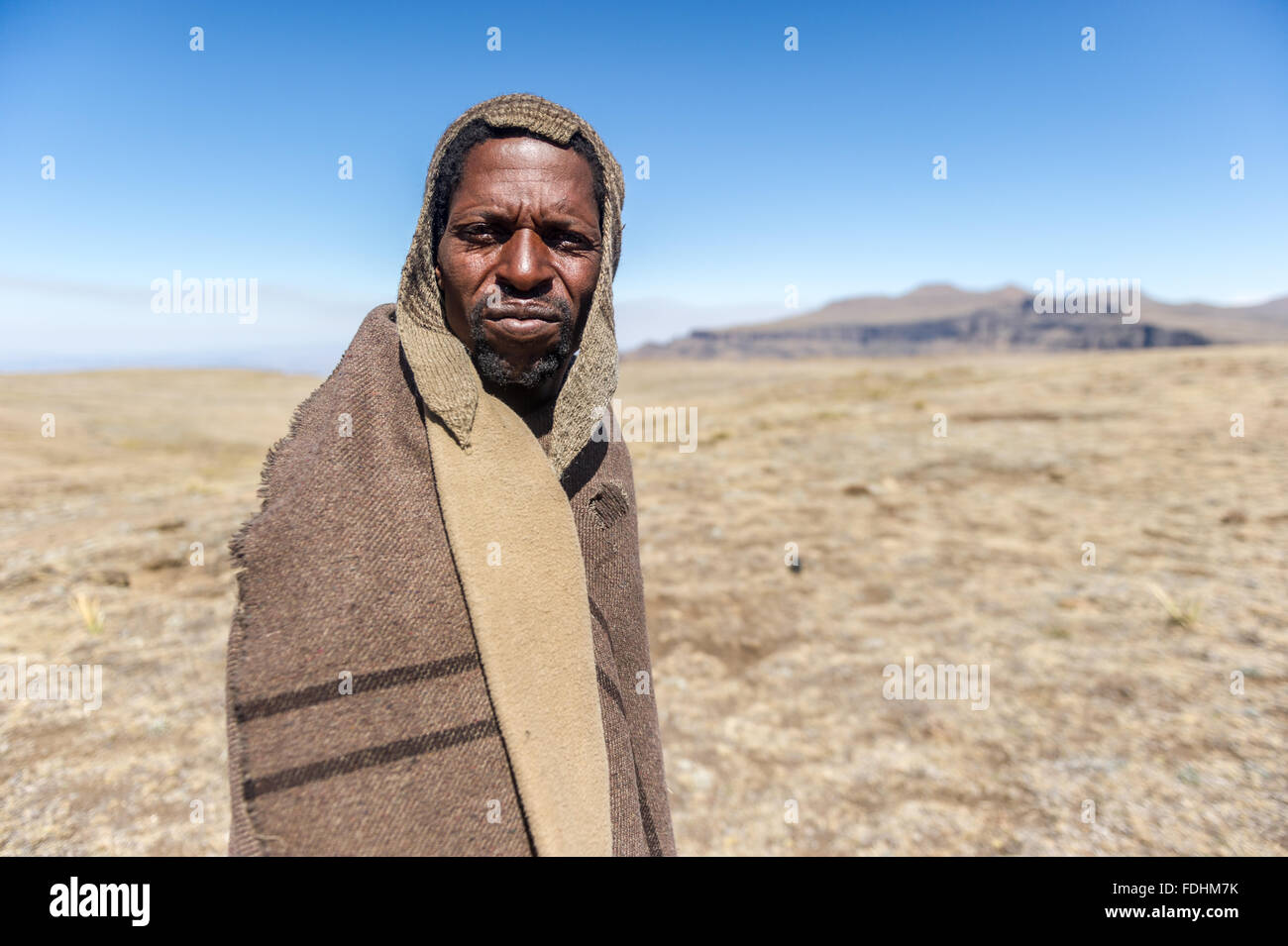Portrait of a local shepherd wrapped in a blanket in the mountains of Lesotho, Africa Stock Photo