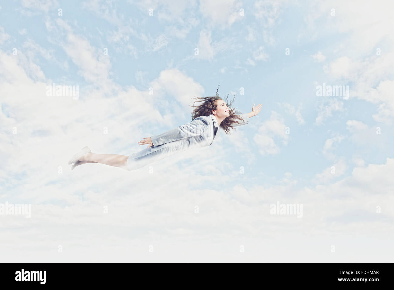 Young pretty businesswoman flying in blue sky Stock Photo