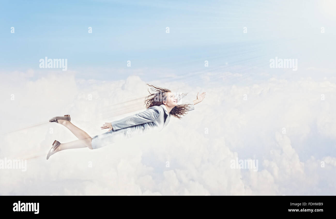 Young pretty businesswoman flying in blue sky Stock Photo