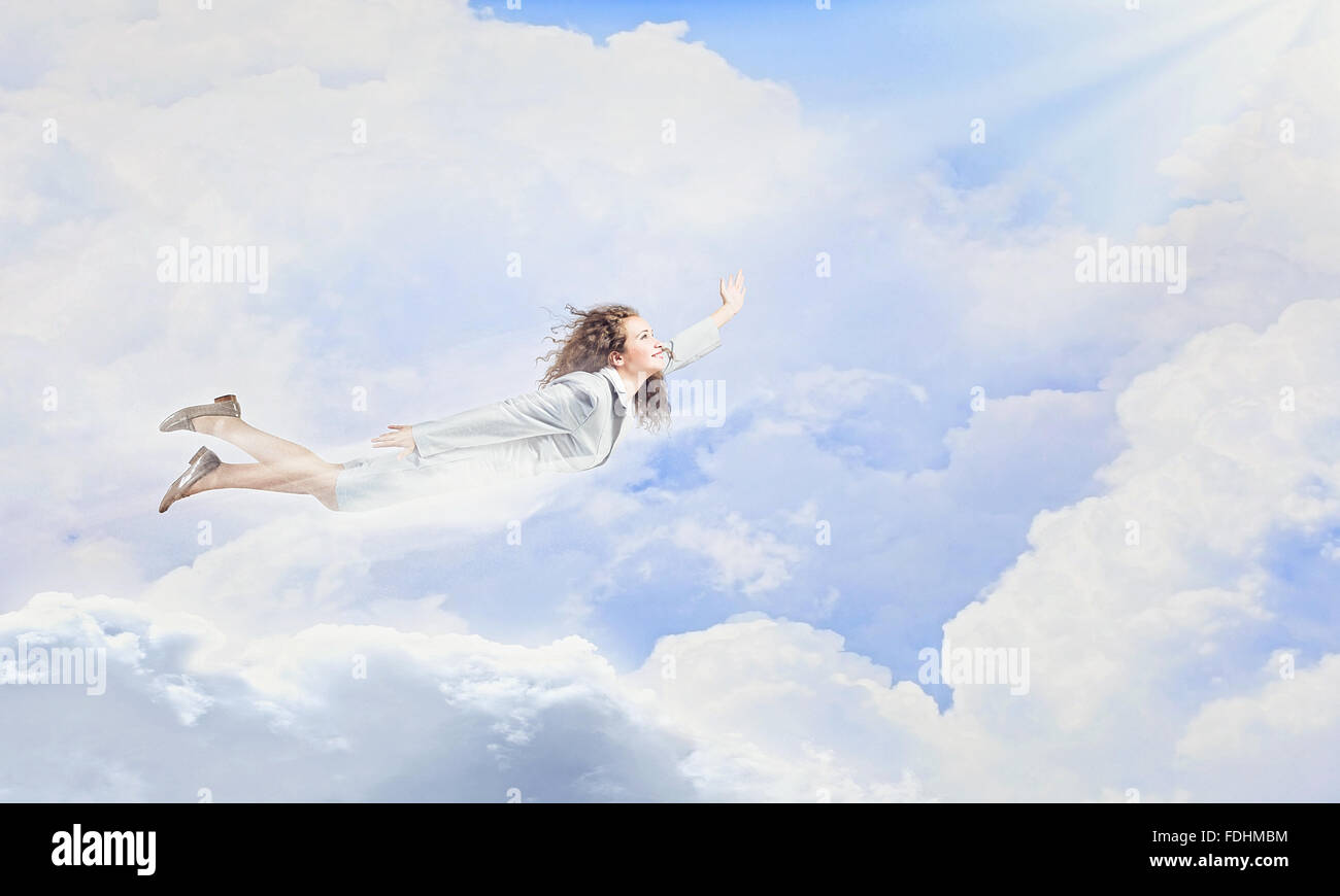 Young pretty businesswoman flying in blue sky Stock Photo