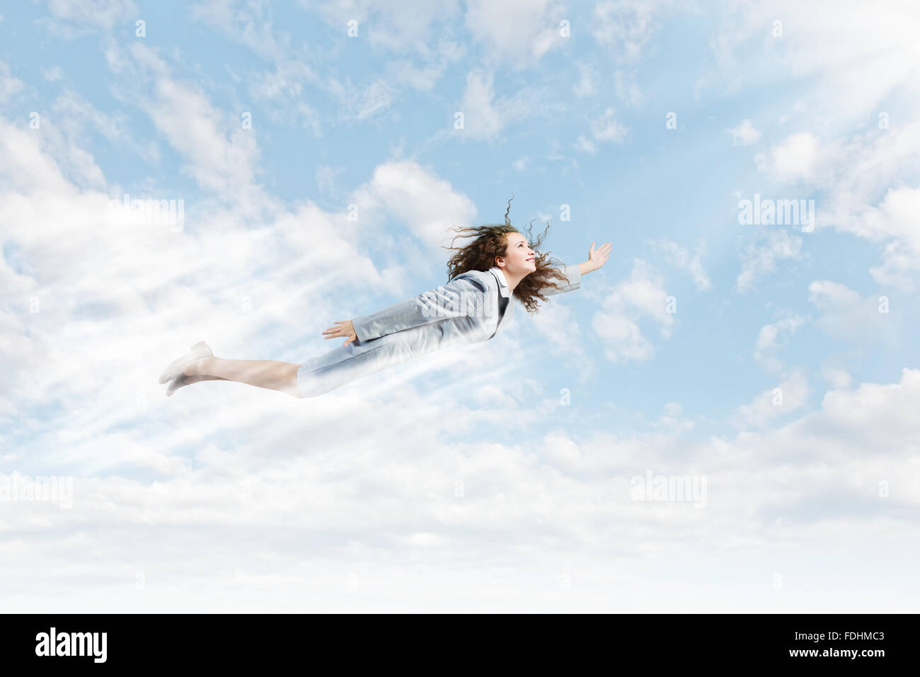 Young pretty businesswoman flying in blue sky Stock Photo