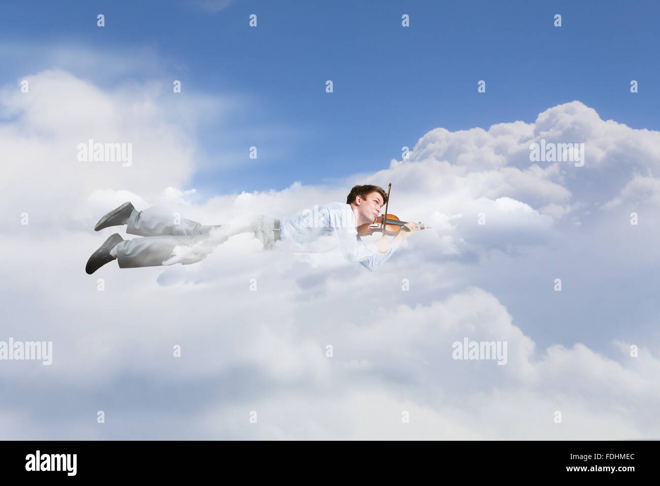 Young businessman flying in sky and playing violin Stock Photo - Alamy