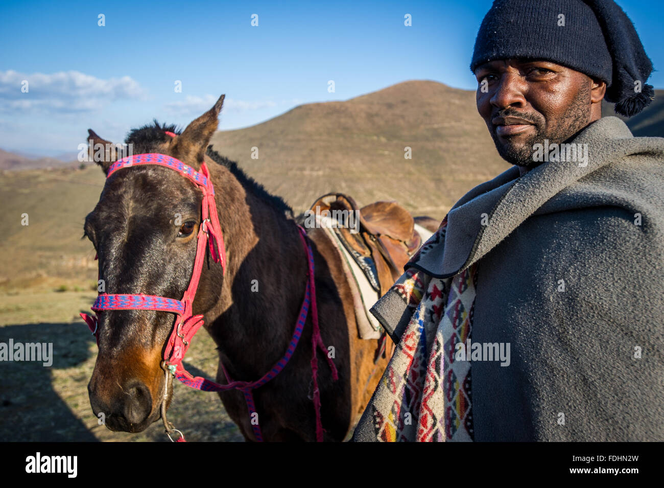 Portrait of a man and his horse in front of a mountain in Lesotho, Africa Stock Photo