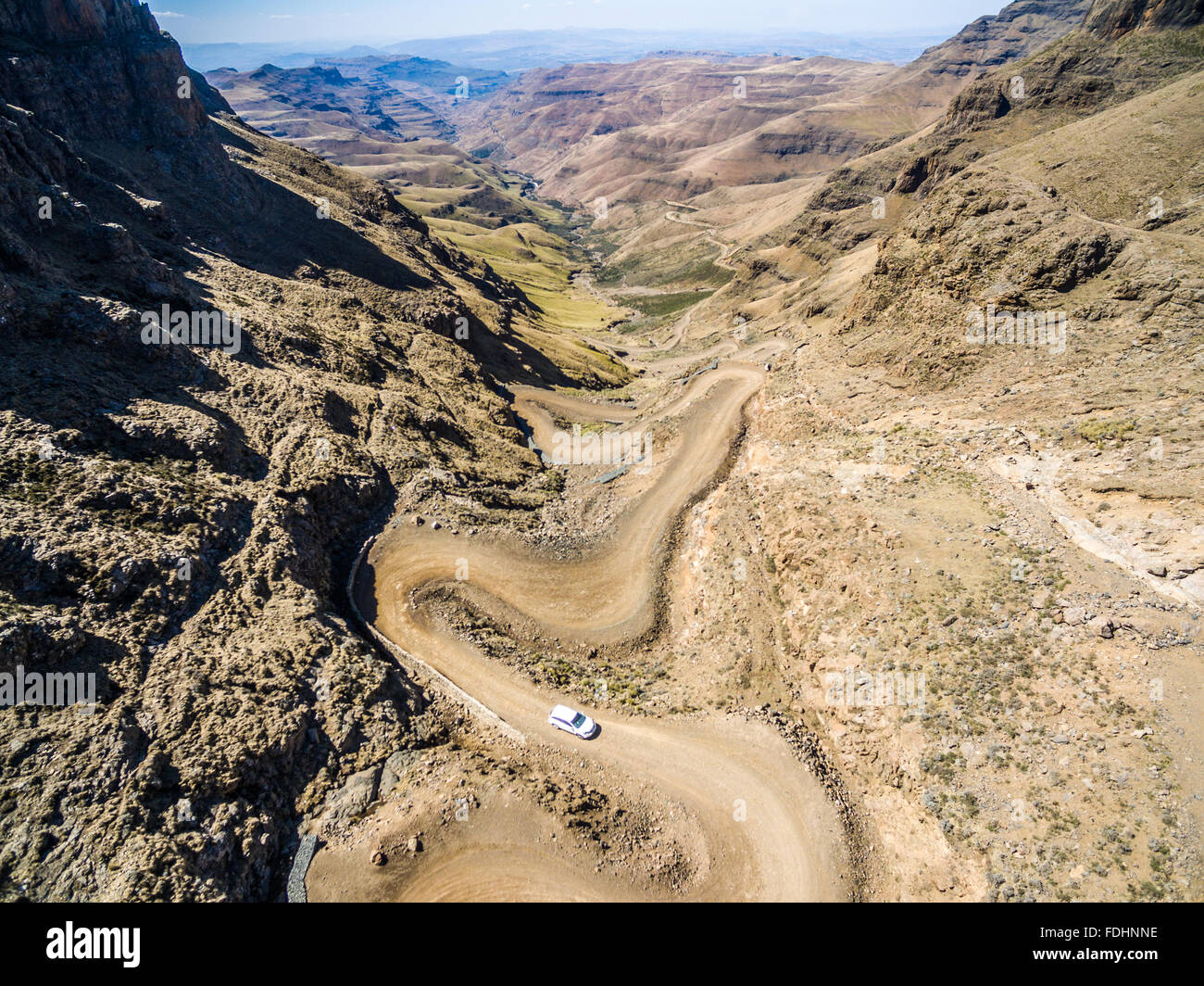 SUV driving down the winding road in the mountains of Lesotho, Africa Stock Photo