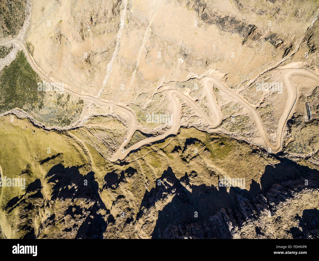 Aerial view of Dirt road and Sani River winding down the mountainside of Lesotho, Africa Stock Photo
