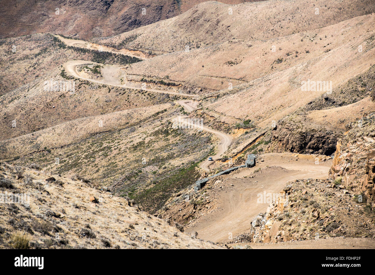 SUV driving down the winding road in the mountains of Lesotho, Africa Stock Photo