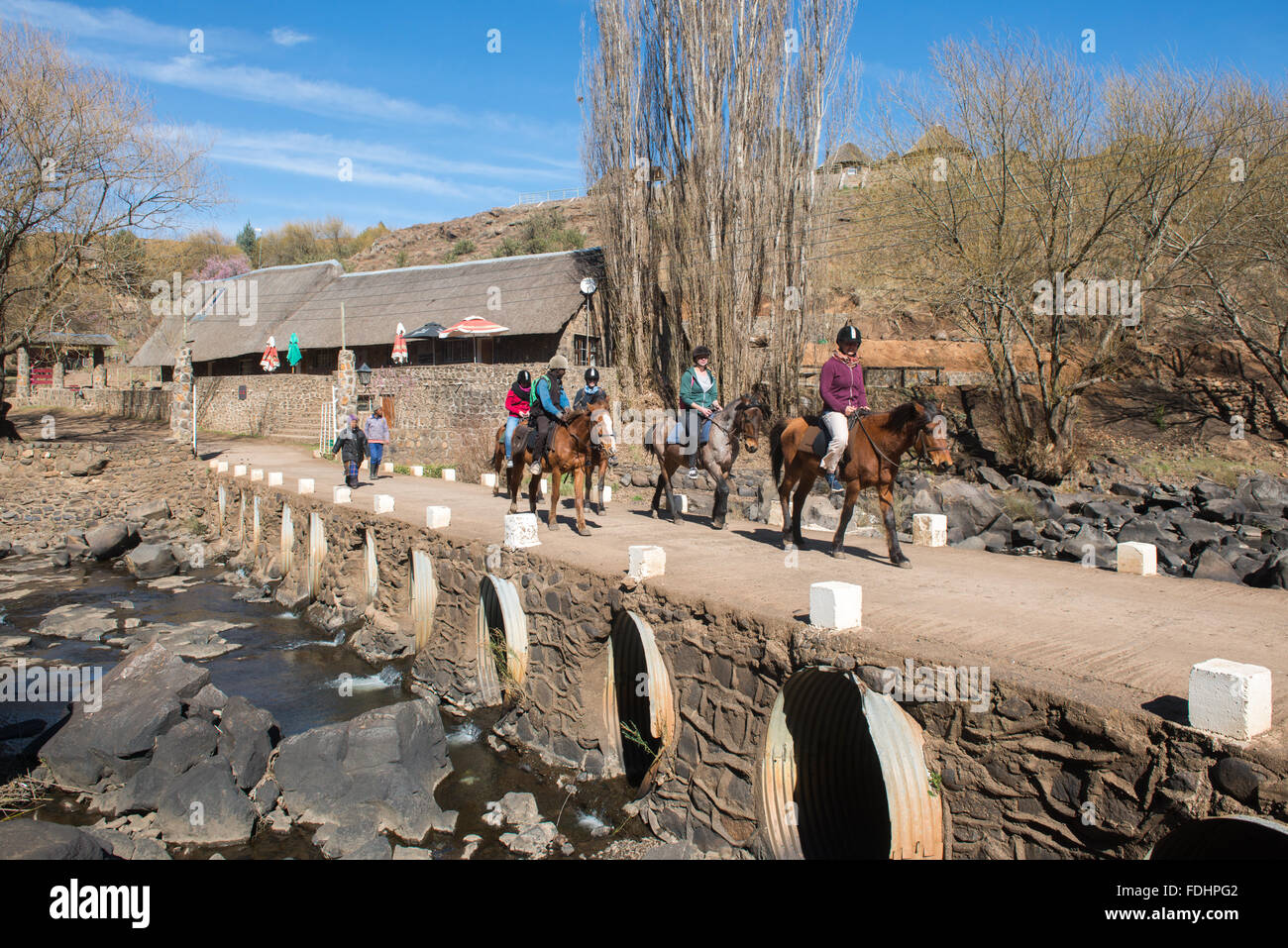 Tourists going on a pony ride over a bridge at the Somenkong Lodge in Somenkong, Lesotho, Africa Stock Photo