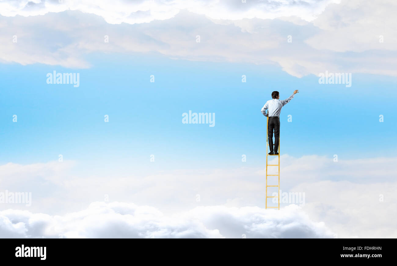 Businessman standing on ladder high in blue sky with clouds Stock Photo ...