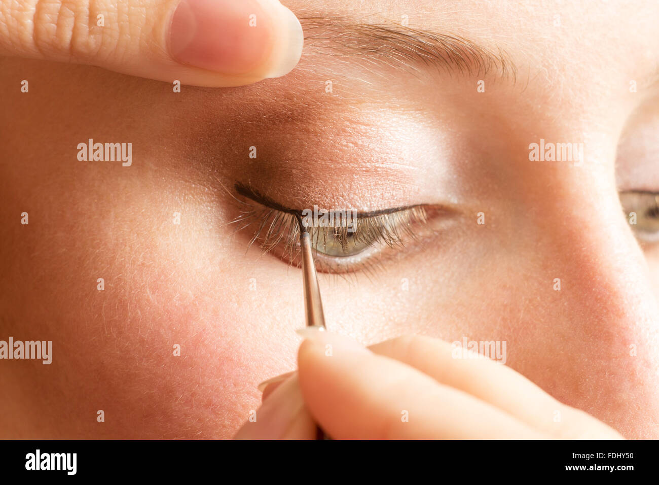 Beautician applying eyeliner on the eyelid. Professional Make-up background Stock Photo