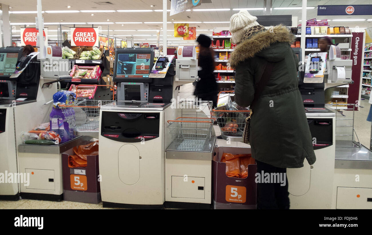 Customer using self checkout till at a Sainsburys supermarket store in