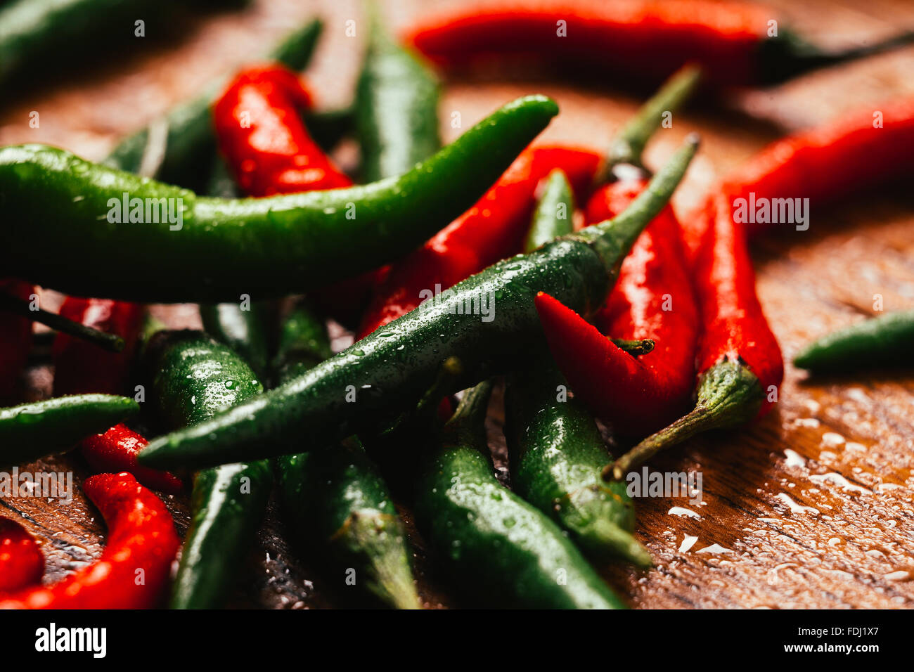 red and green chili peppers close up on wooden background Stock Photo ...
