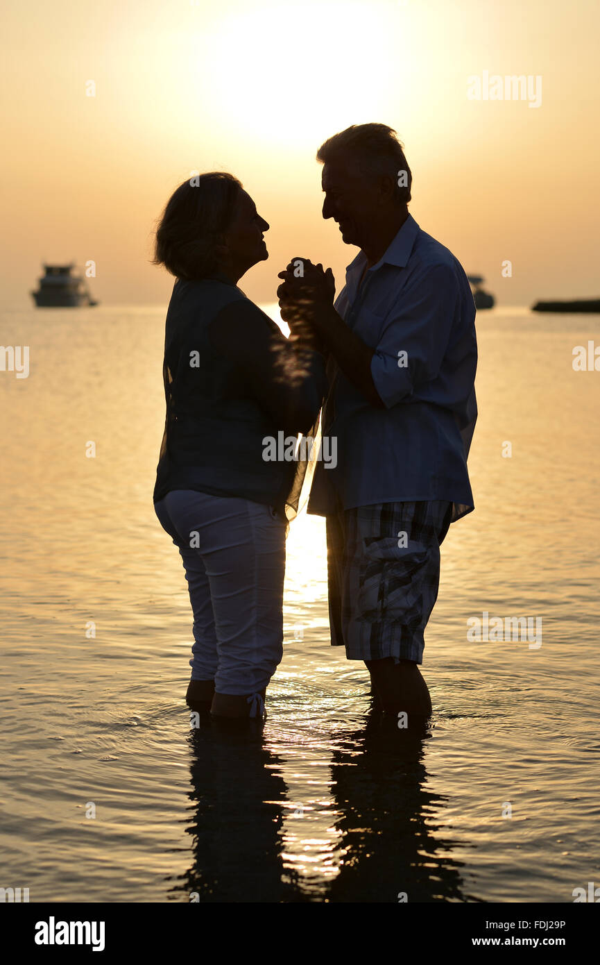 Mature couple relaxing on beach Stock Photo - Alamy