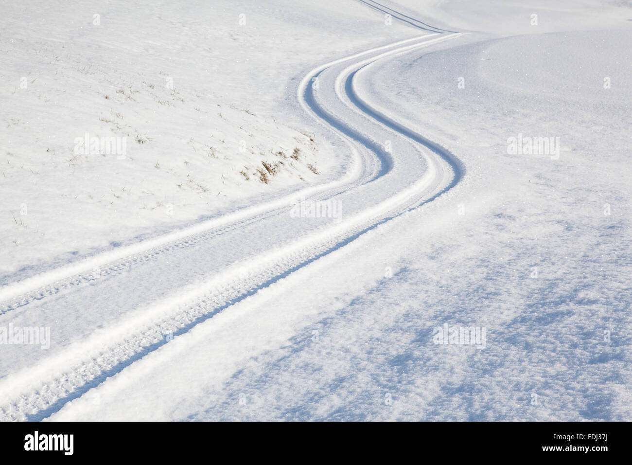 Car tire track on a empty winter road Stock Photo