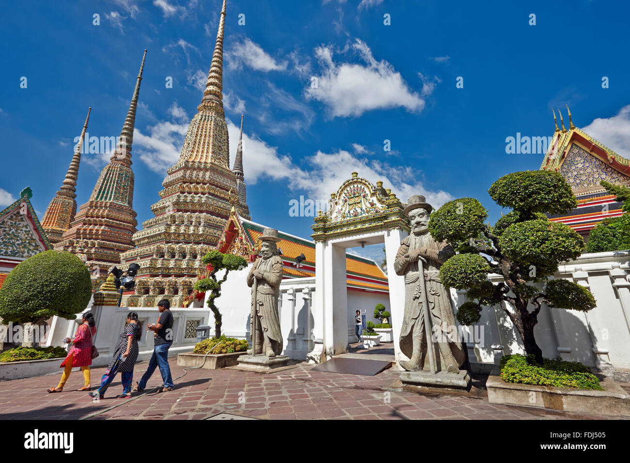 People walking by the Phra Maha Chedi Si Rajakarn, The Great Pagodas of Four Kings in the Wat Pho Temple. Bangkok, Thailand. Stock Photo