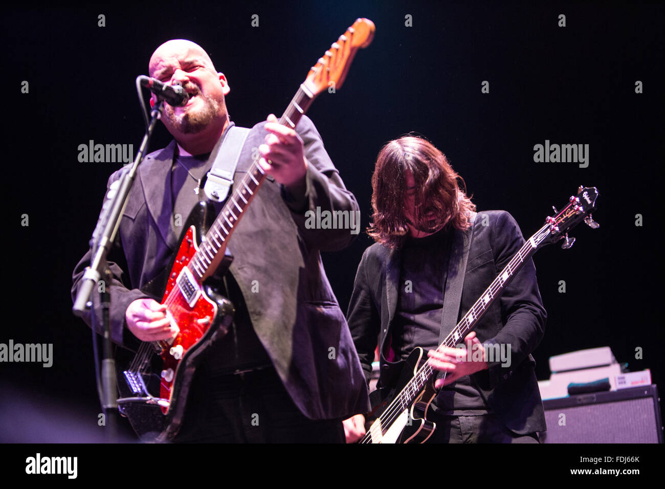 Alain Johannes singing and playing guitar with Dave Grohl in the background Stock Photo