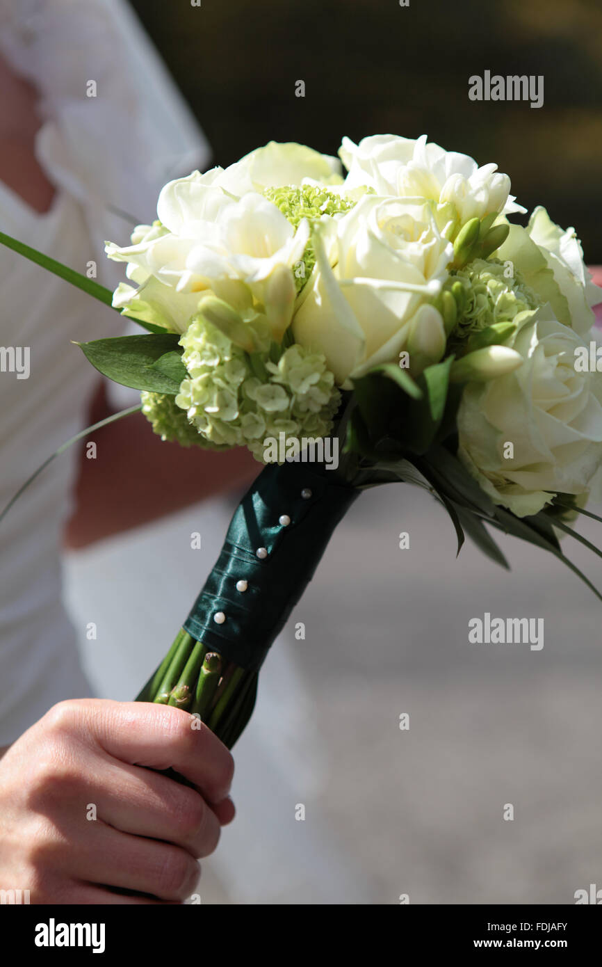 Bride holding white wedding bouquet Stock Photo