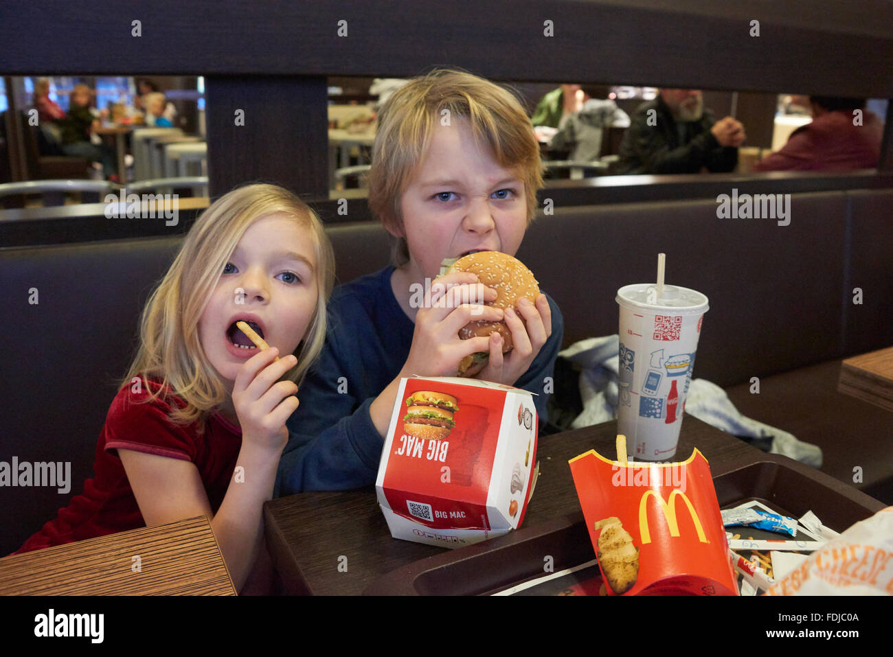 Siblings, brother and sister eating in fast food restaurant Stock Photo